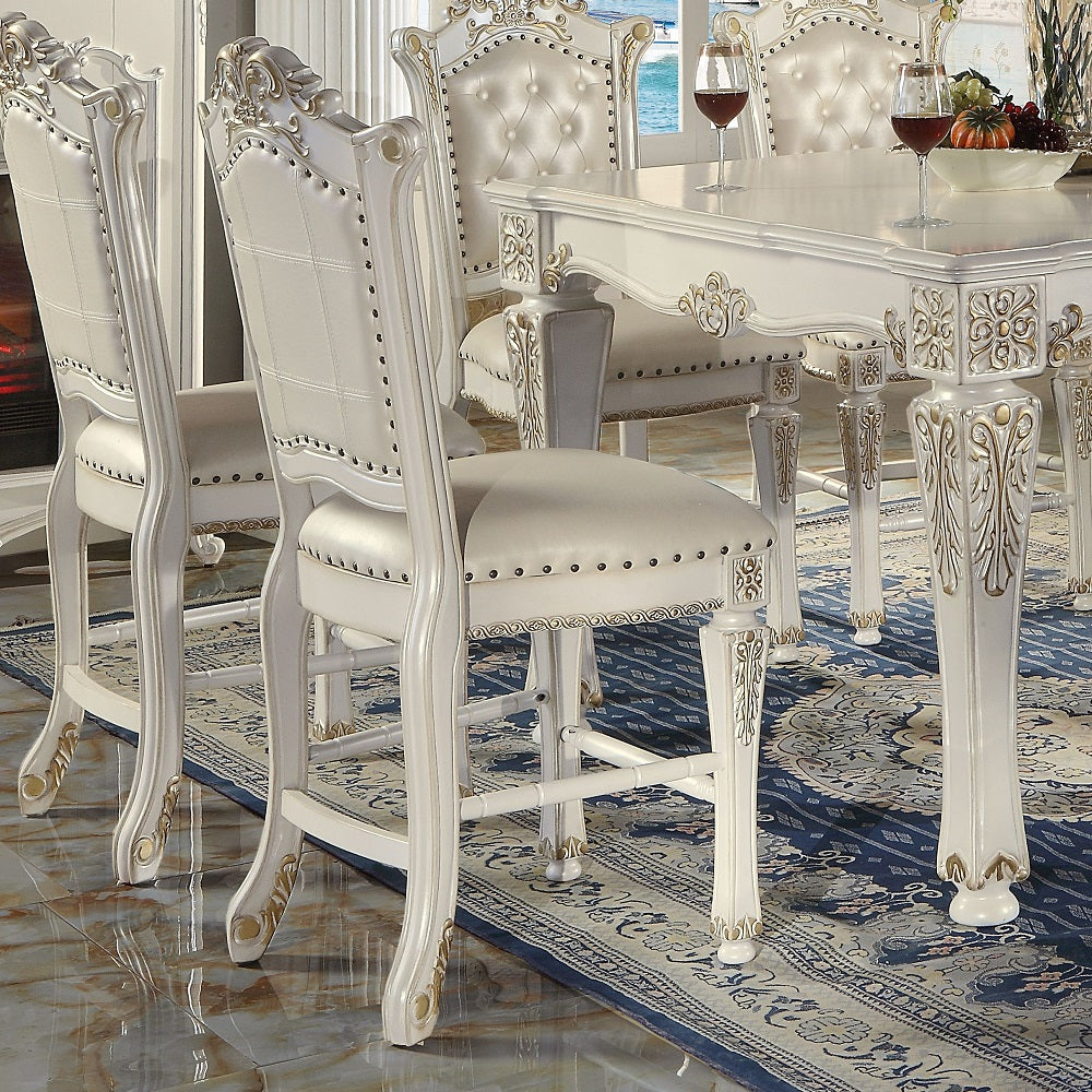 Ornate white tufted dining chairs with gold accents
