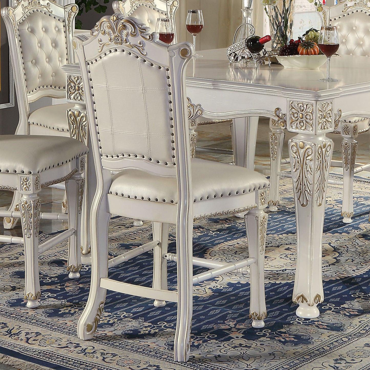 White tufted upholstered dining chair with ornate carved legs and brass tacks