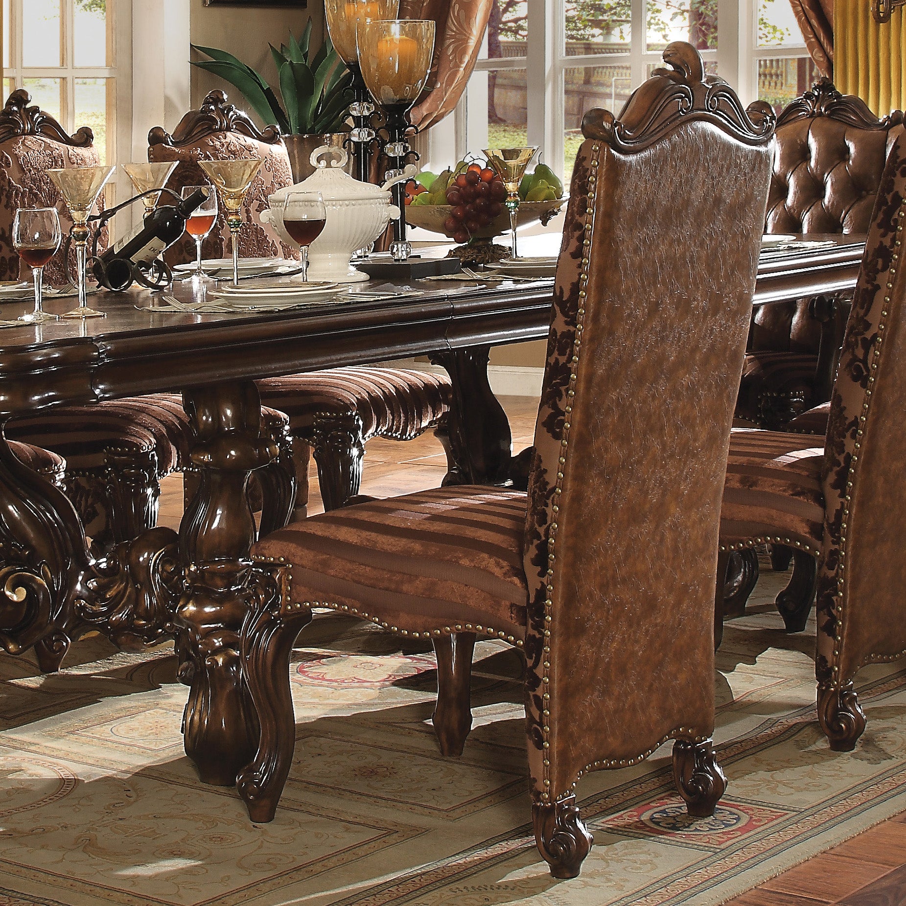 Ornate dark wood dining chair with distressed brown leather upholstery and gold nailhead trim
