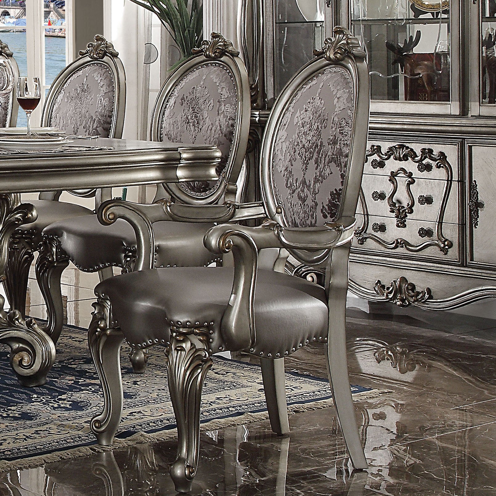 Ornate silver dining chair with upholstered grey damask seat and back