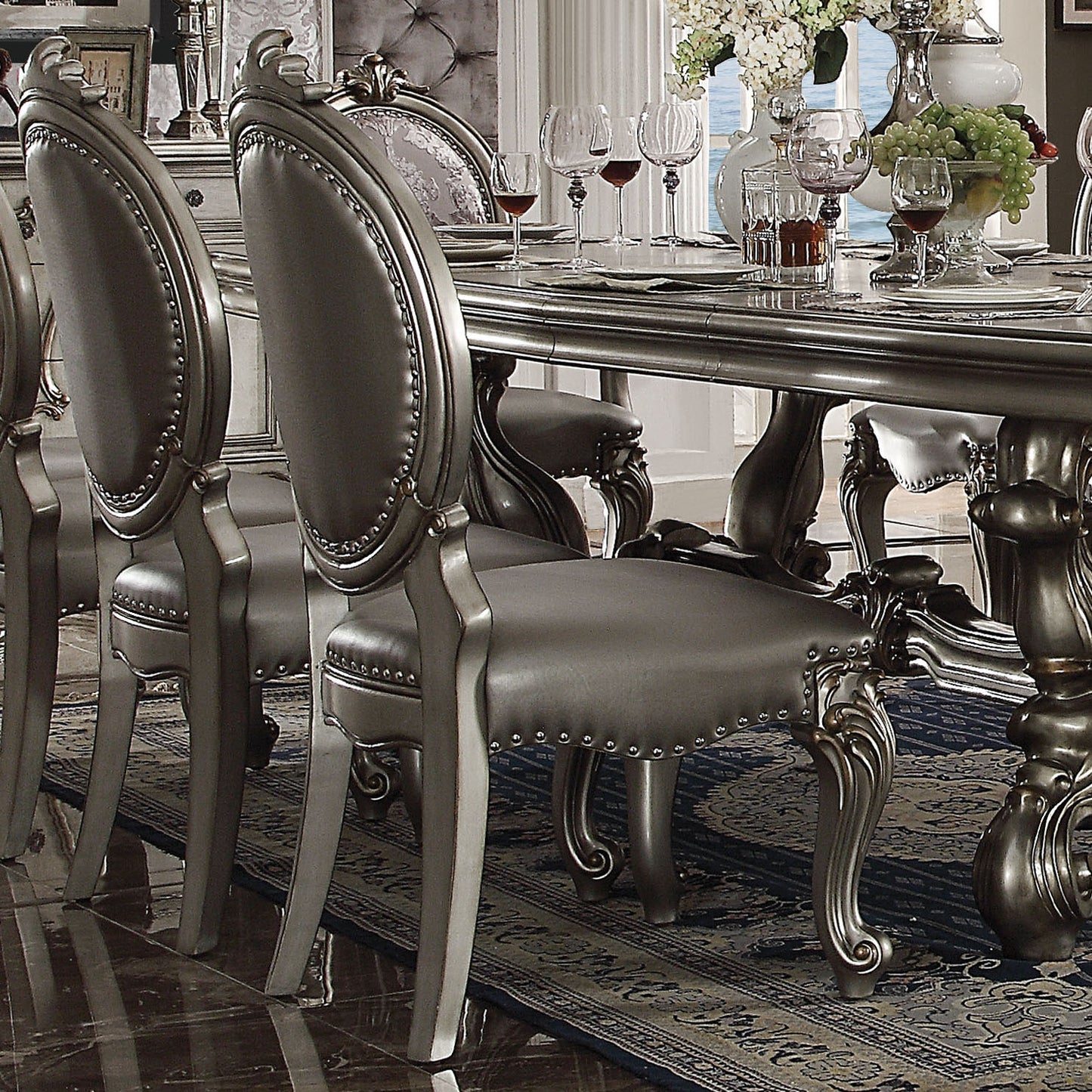 Elegant upholstered dining chair with silver leather and decorative nailhead trim