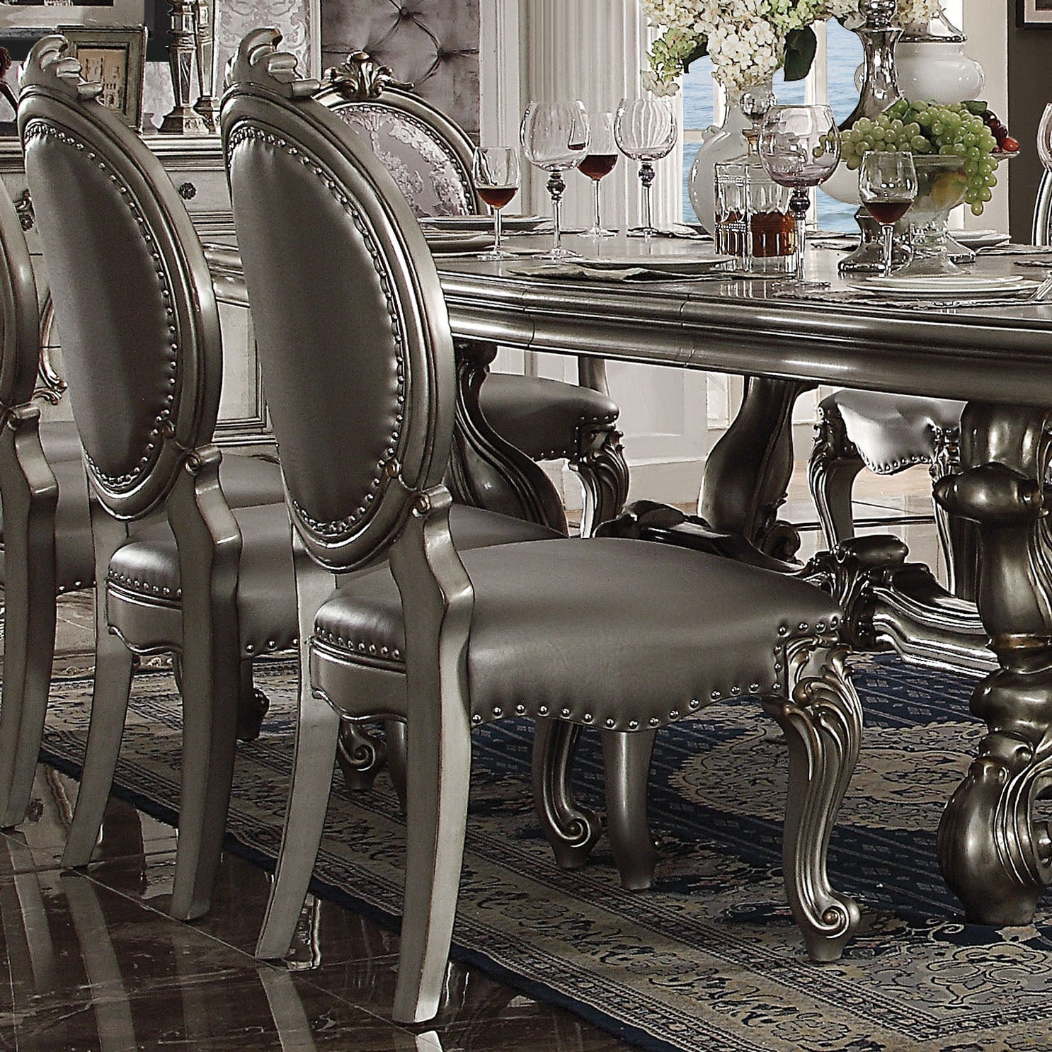 Elegant upholstered dining chair with silver leather and decorative nailhead trim