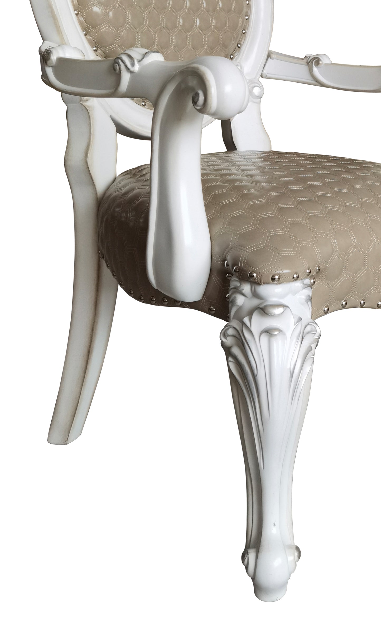 Close up of ornate carved legs on a white armchair with tan upholstered seat