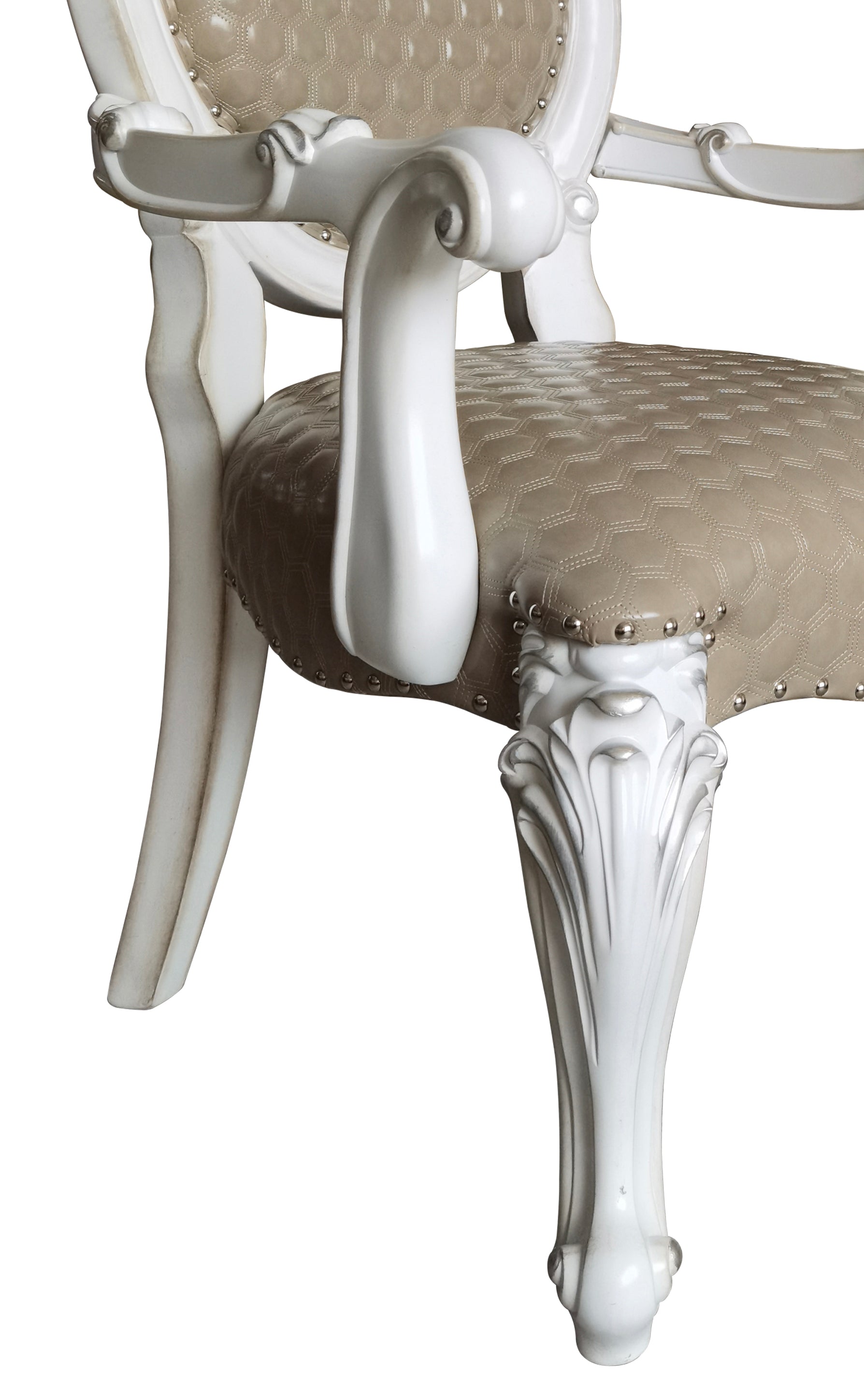 Close up of ornate carved legs on a white armchair with tan upholstered seat