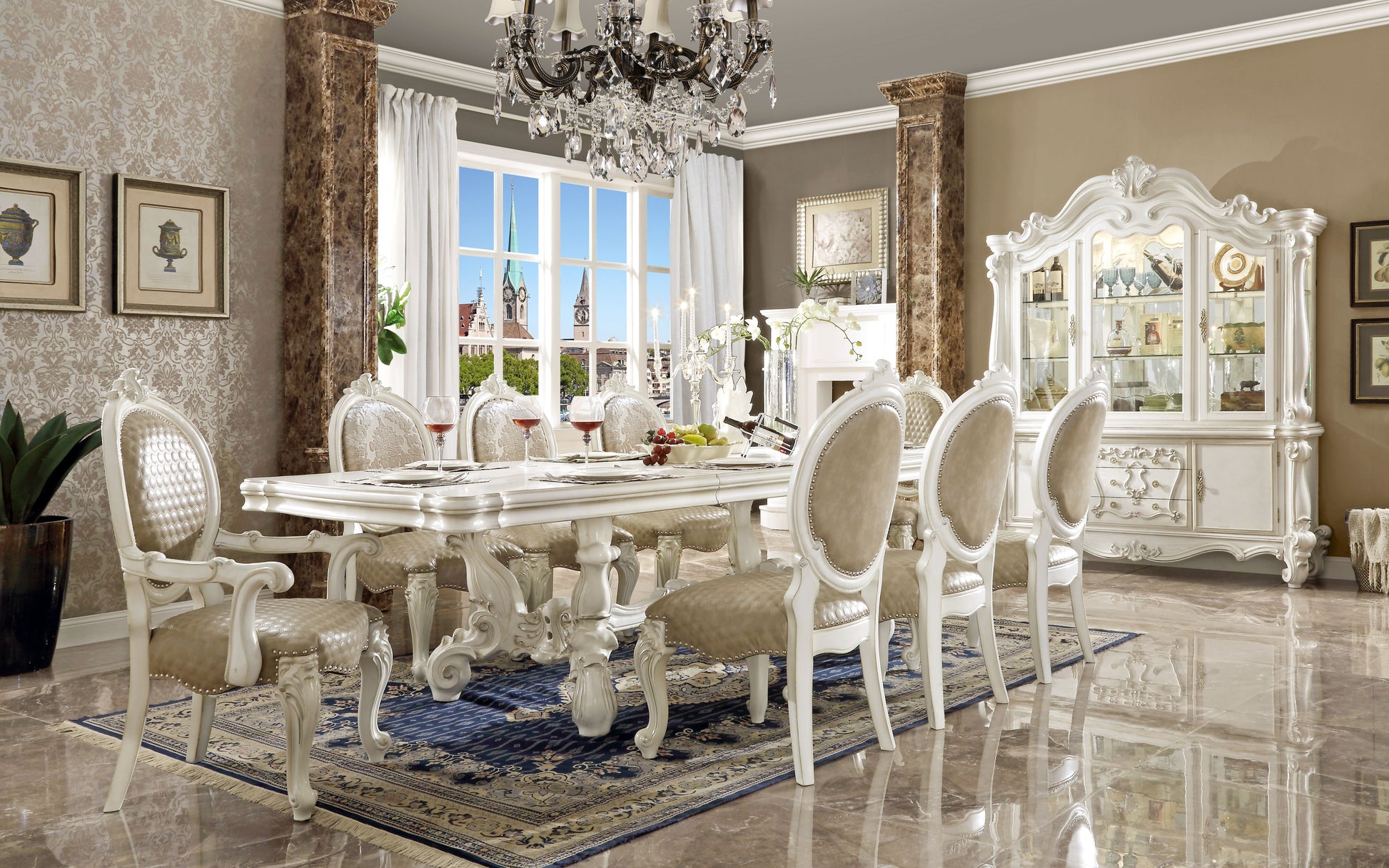 Ornate white carved dining table with upholstered chairs set for a formal meal