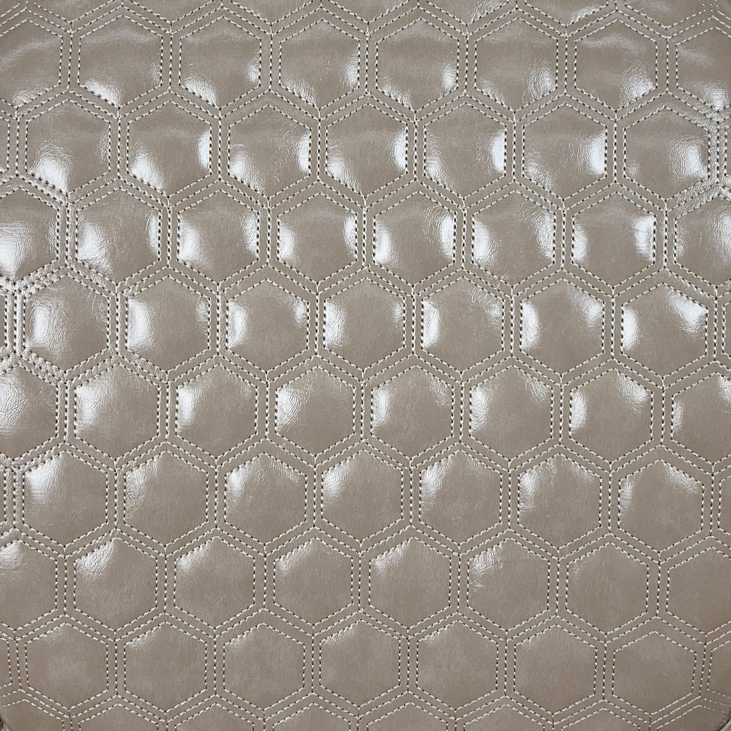 Taupe faux leather upholstery with hexagonal quilting and subtle sheen