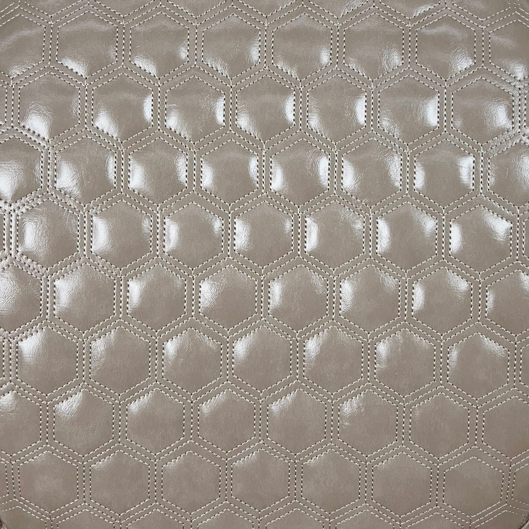 Taupe faux leather upholstery with hexagonal quilting and subtle sheen