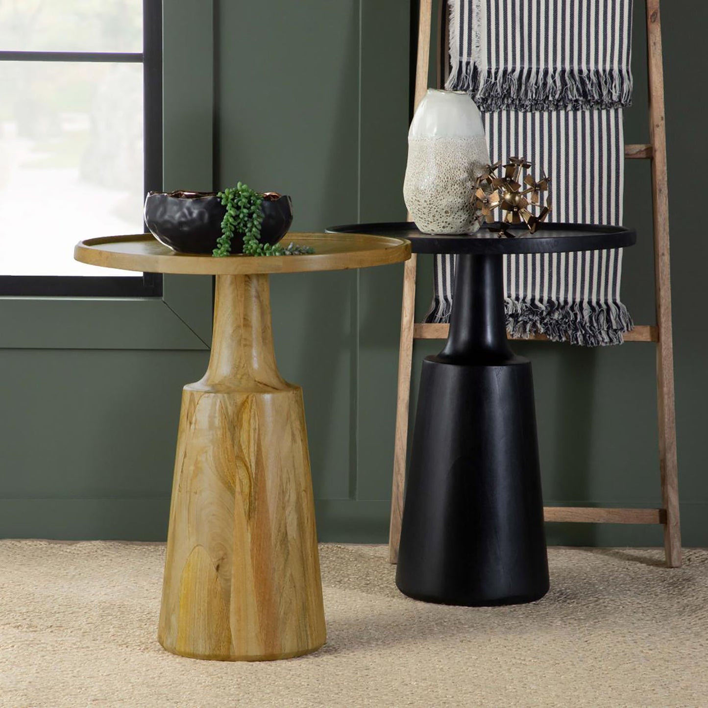 Round wood side table with a golden wood grain finish holding a black planter with a succulent