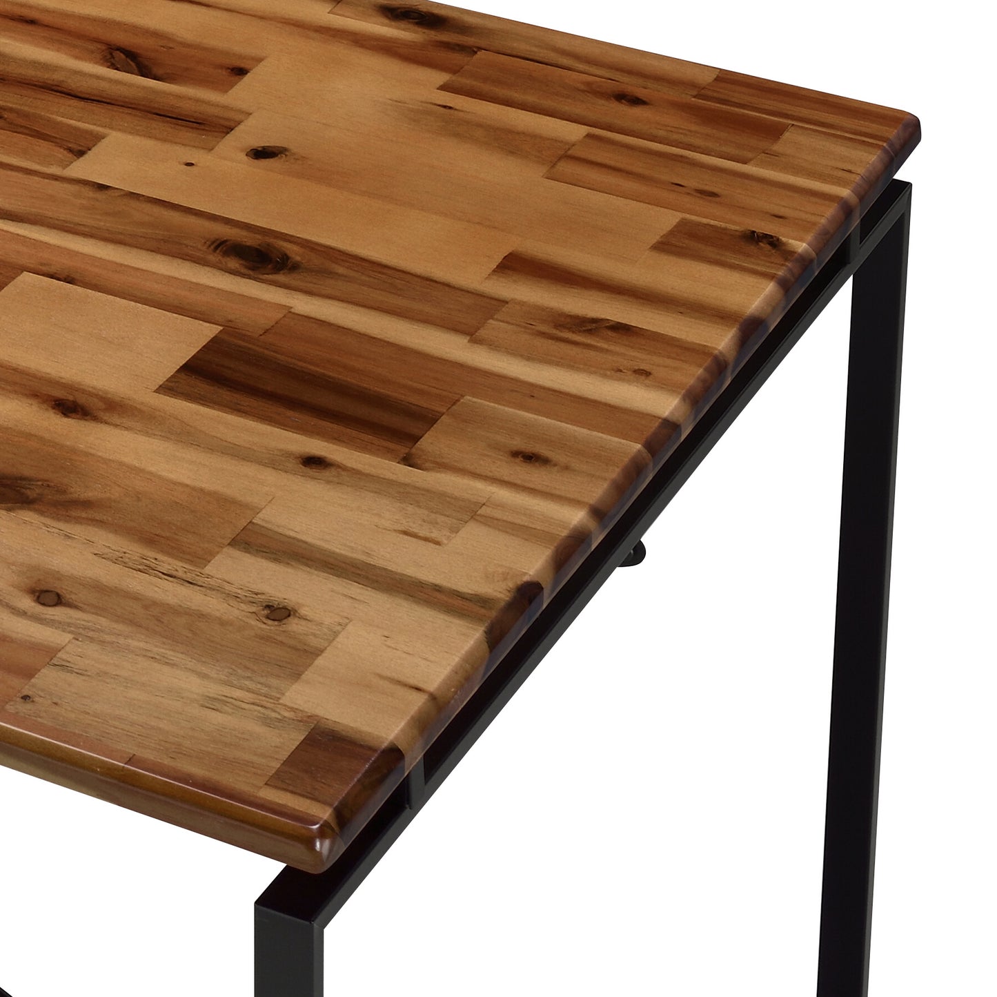 Closeup of a wooden dining table top with a natural acacia wood finish and black metal legs