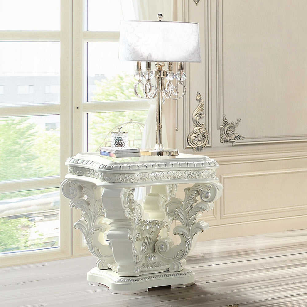 Ornate white carved wood side table with a crystal and gold lamp