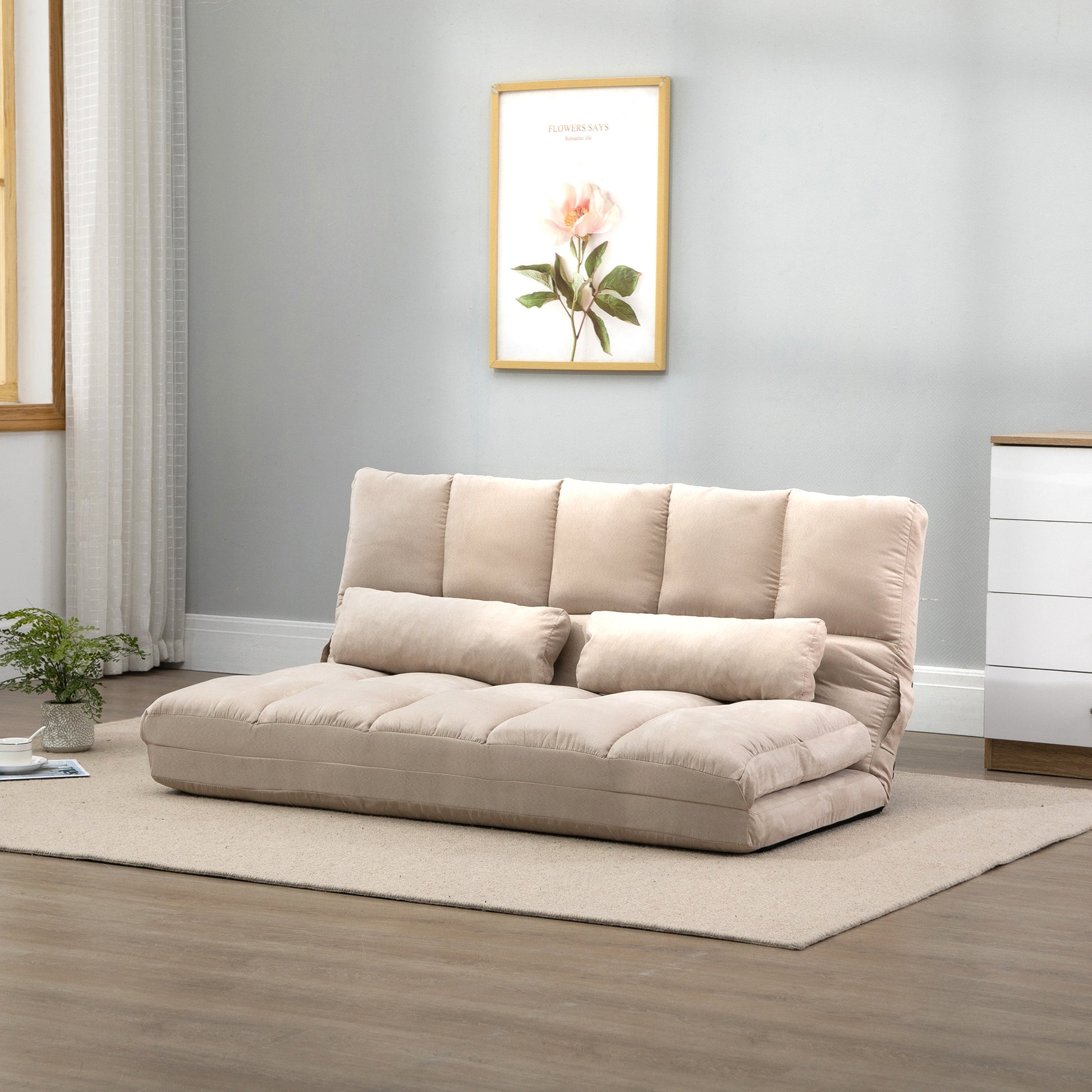 Beige convertible sofa bed with plush cushions and two accent pillows
