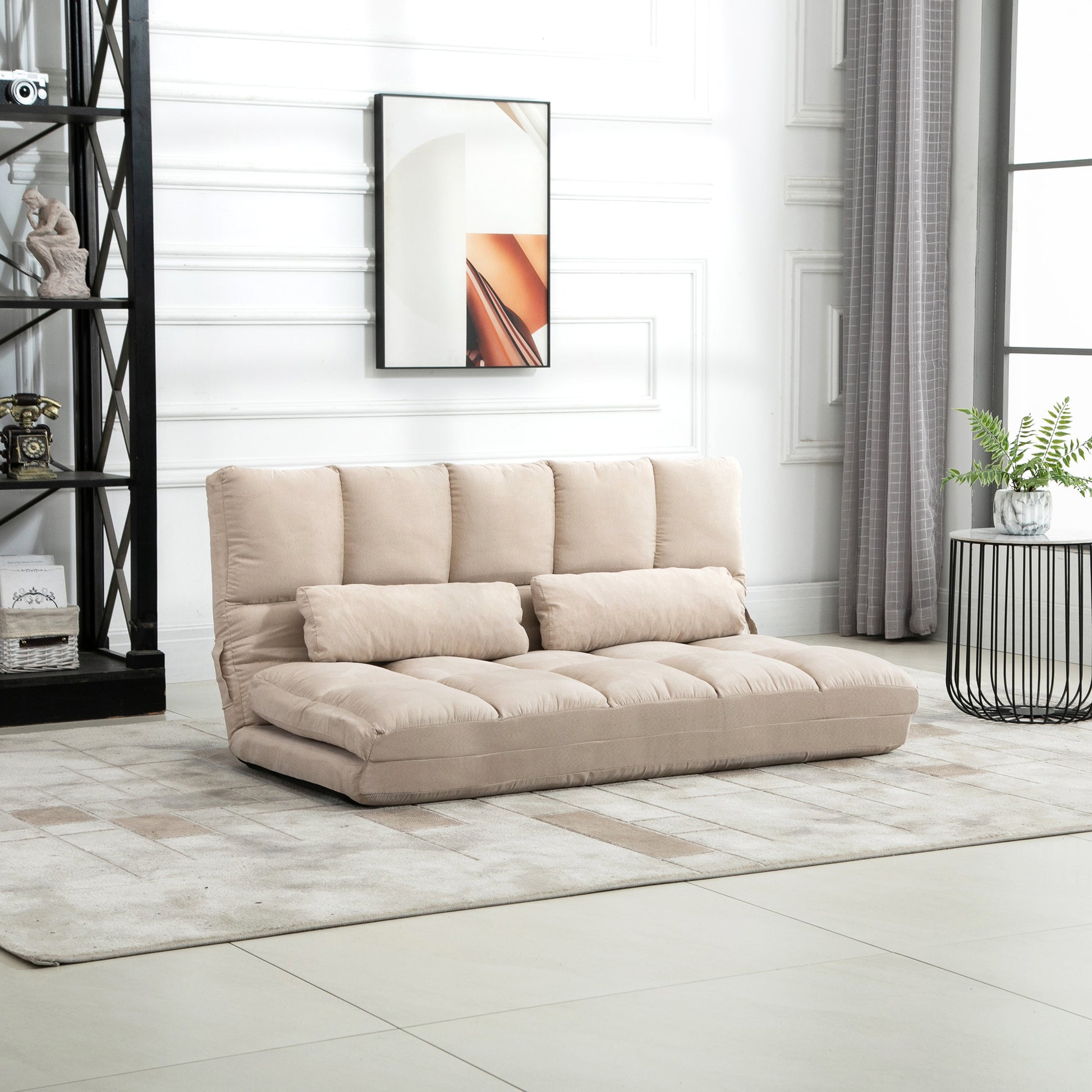 Beige convertible sofa with two lumbar pillows on a geometric rug