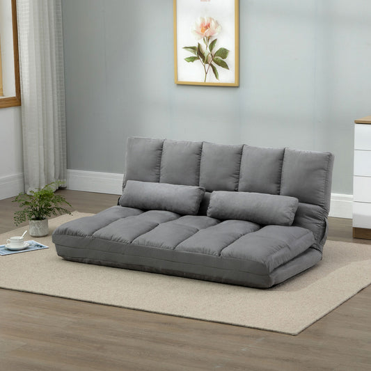 Grey upholstered futon sofa bed with two bolster pillows perfect for small living spaces