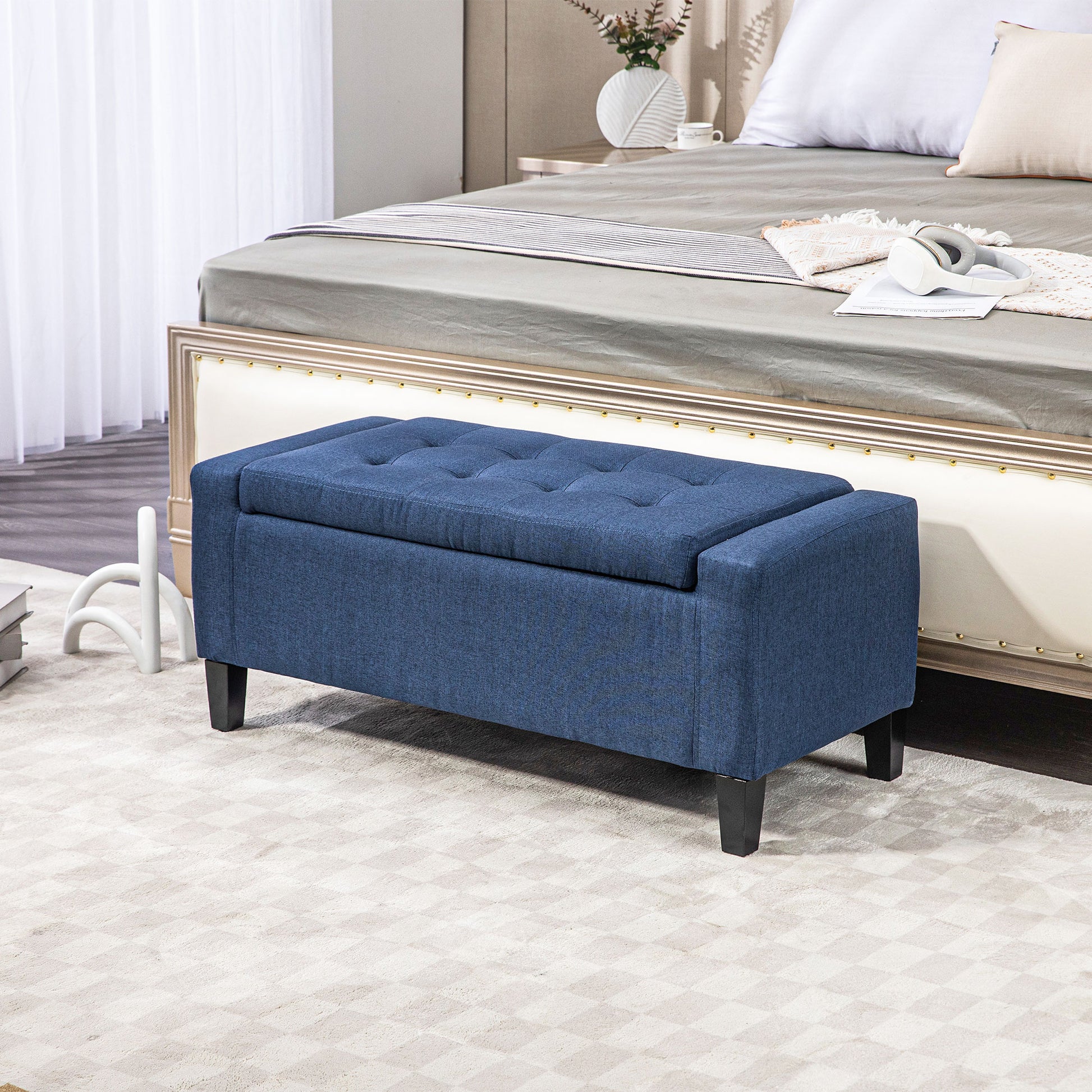 Tufted navy blue fabric storage bench with dark wooden legs