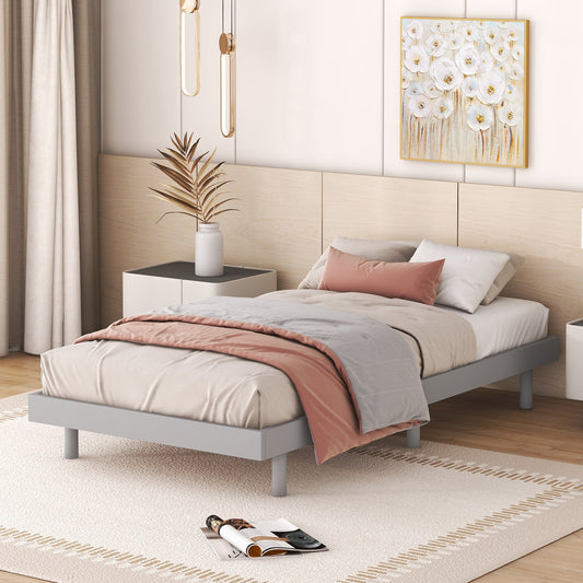 Minimalist grey metal bed frame with neutral bedding and pink accent pillow