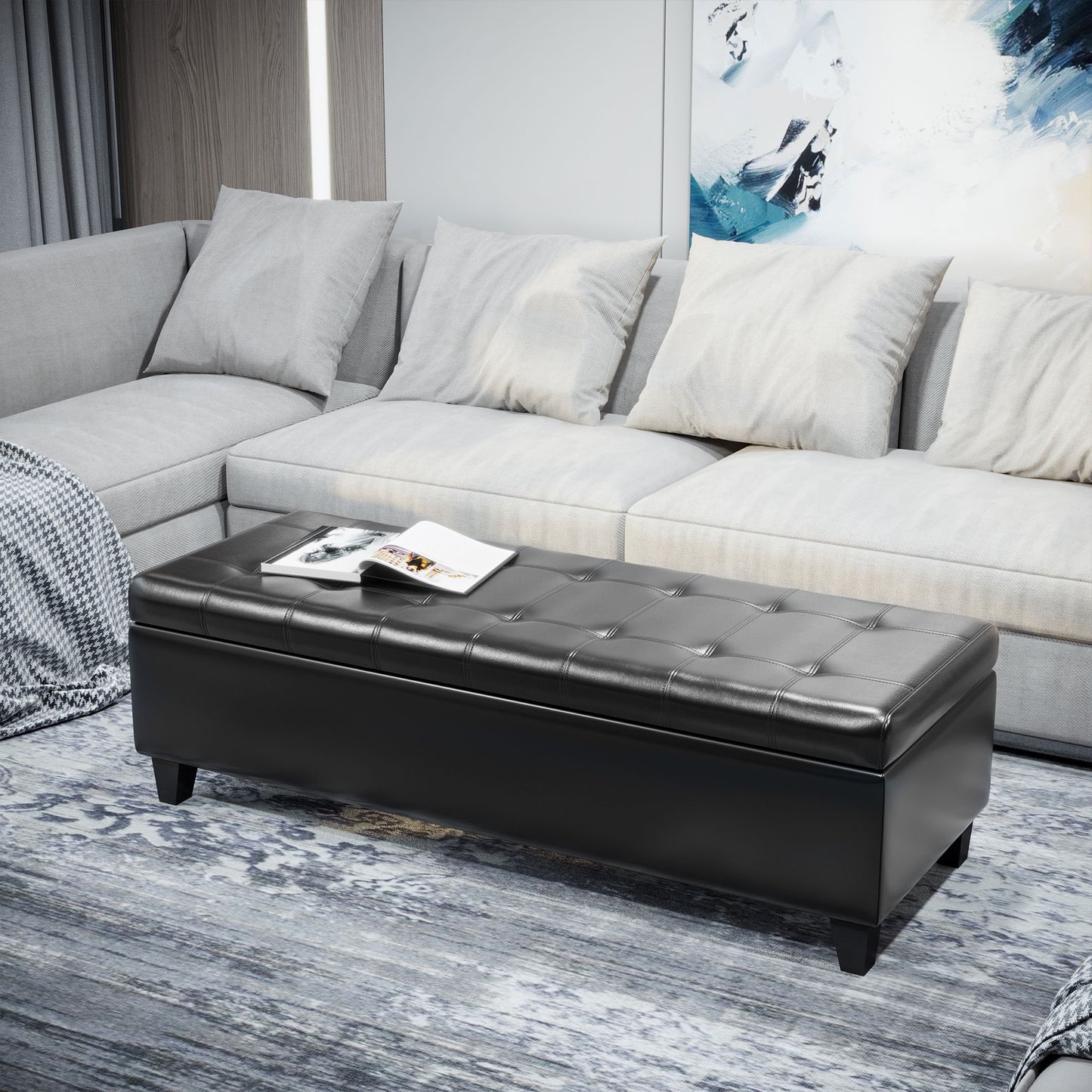 Tufted black faux leather storage ottoman with decorative stitching and wooden legs