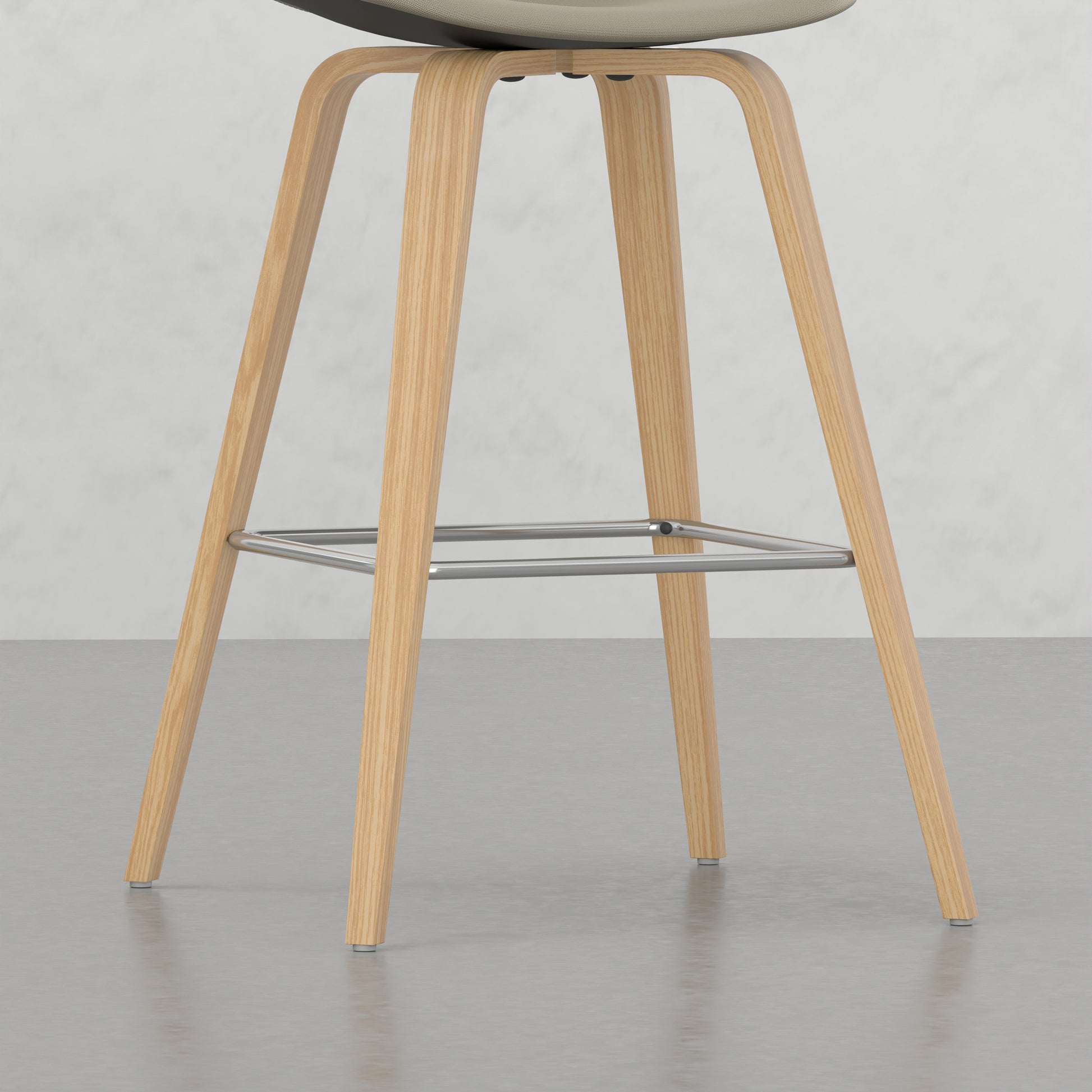 Modern beige upholstered bar stool with natural wood legs and chrome footrest