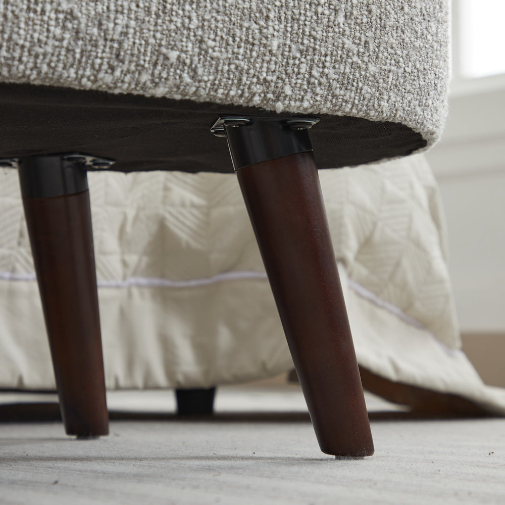 Tapered dark wood furniture legs on a textured armchair showing sturdy construction