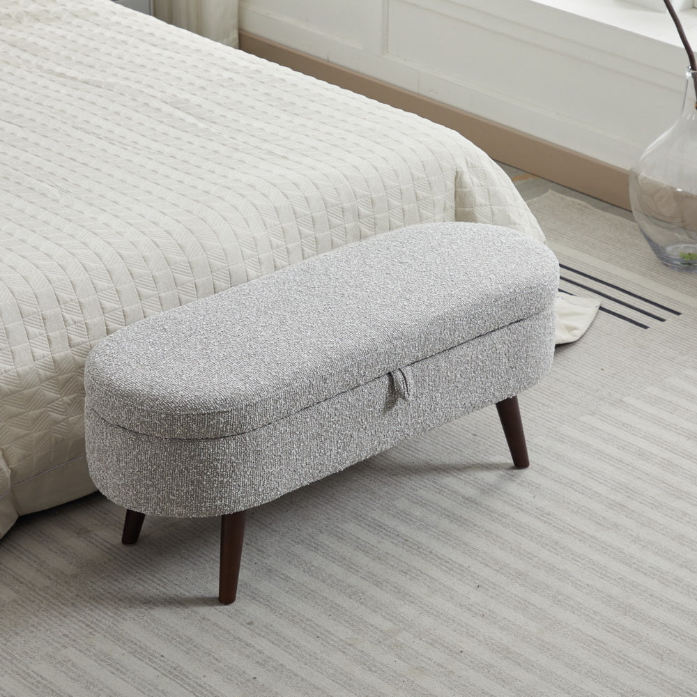 Gray upholstered storage bench with dark wooden legs perfect for bedroom foot of bed