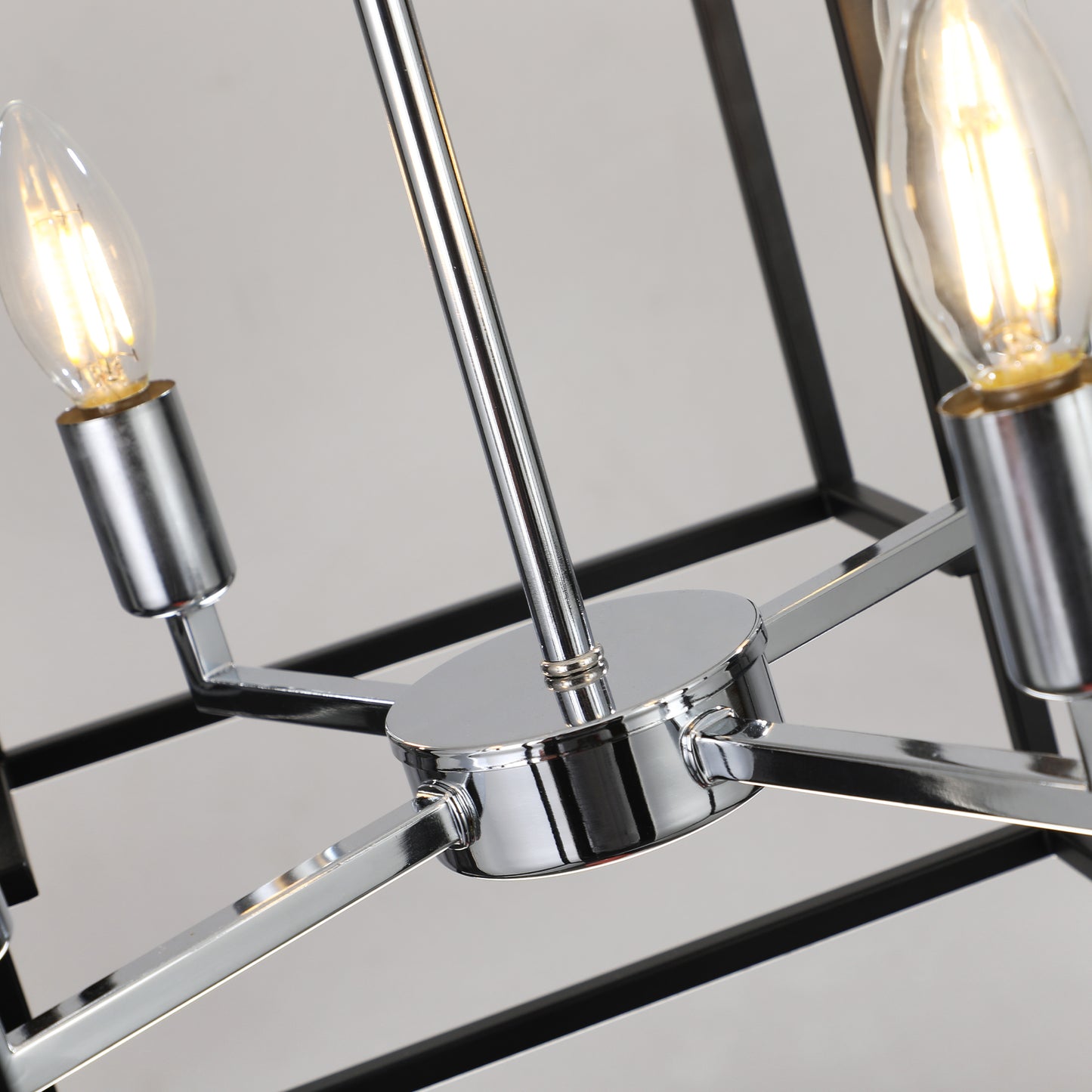 Closeup of a modern black and chrome chandelier with clear Edison bulbs illuminating