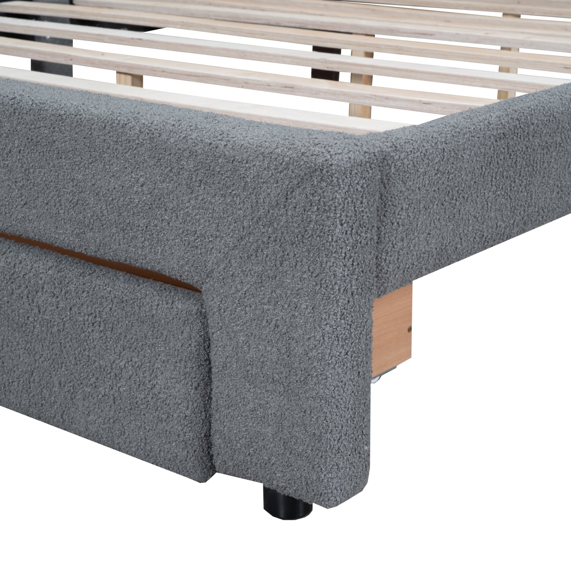 Closeup of grey textured boucle fabric bed frame corner with wooden slats