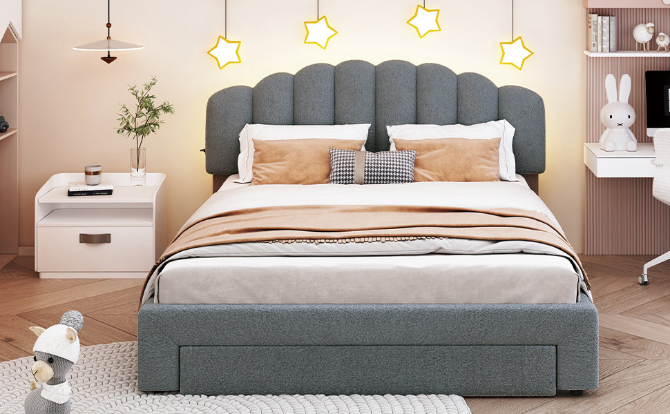 Gray upholstered bed with a scalloped headboard and storage drawers