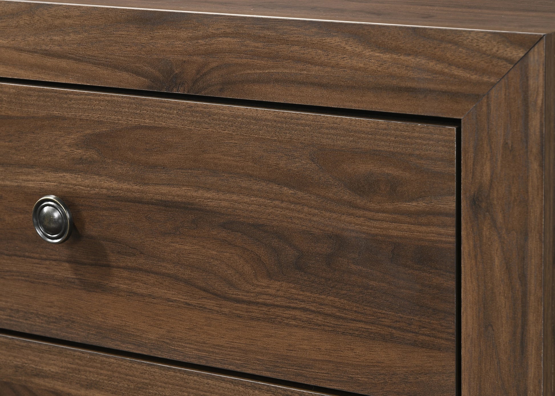 Dark walnut wood dresser drawer front with antique bronze knob