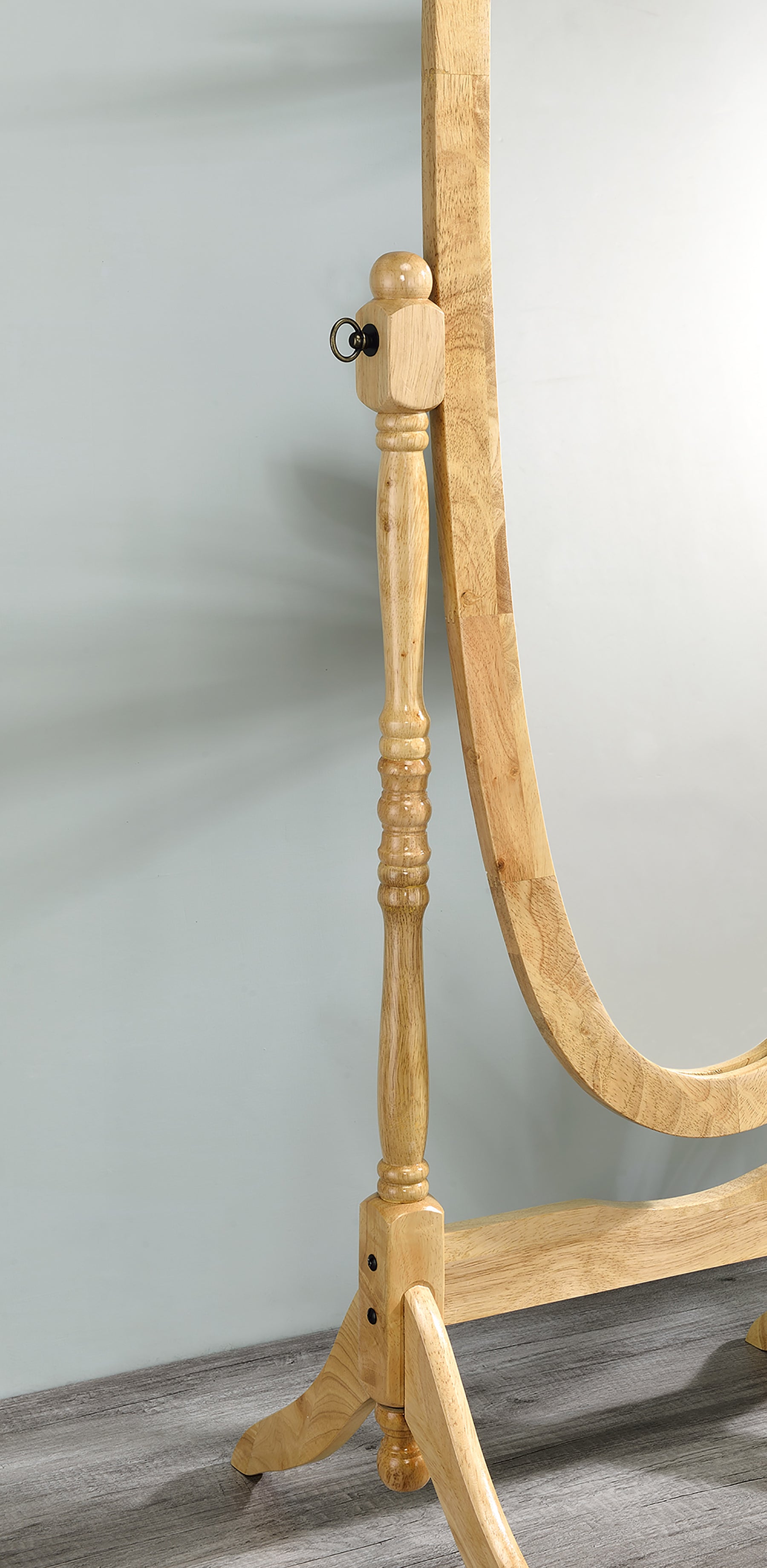 Natural wood cheval mirror with ornate turned spindle detail and brass ring accent