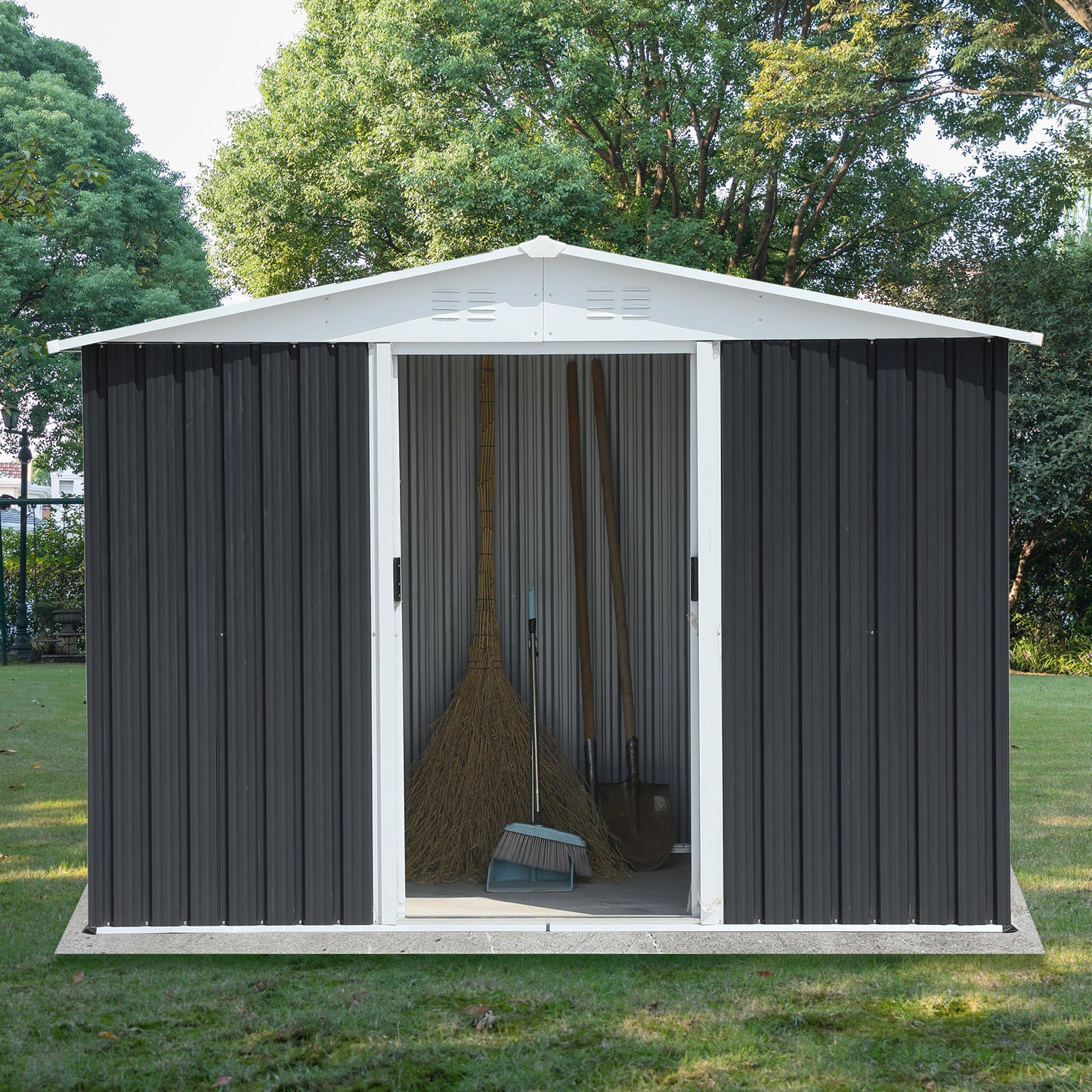 Dark gray corrugated metal shed with white trim open doors revealing gardening tools inside