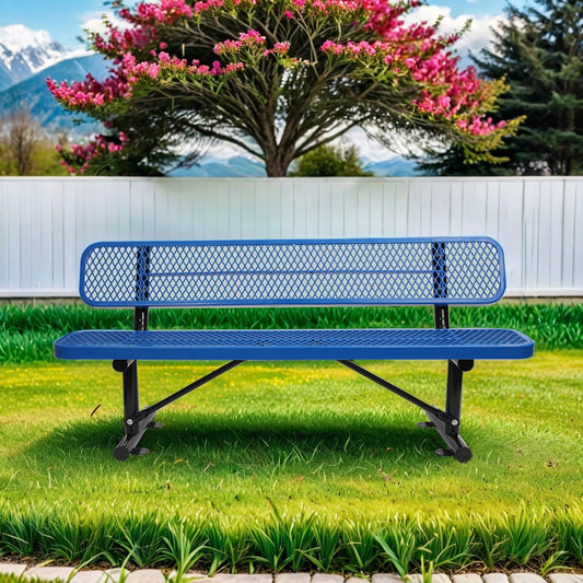 Blue expanded metal park bench with black legs in a grassy yard with mountains and blooming tree