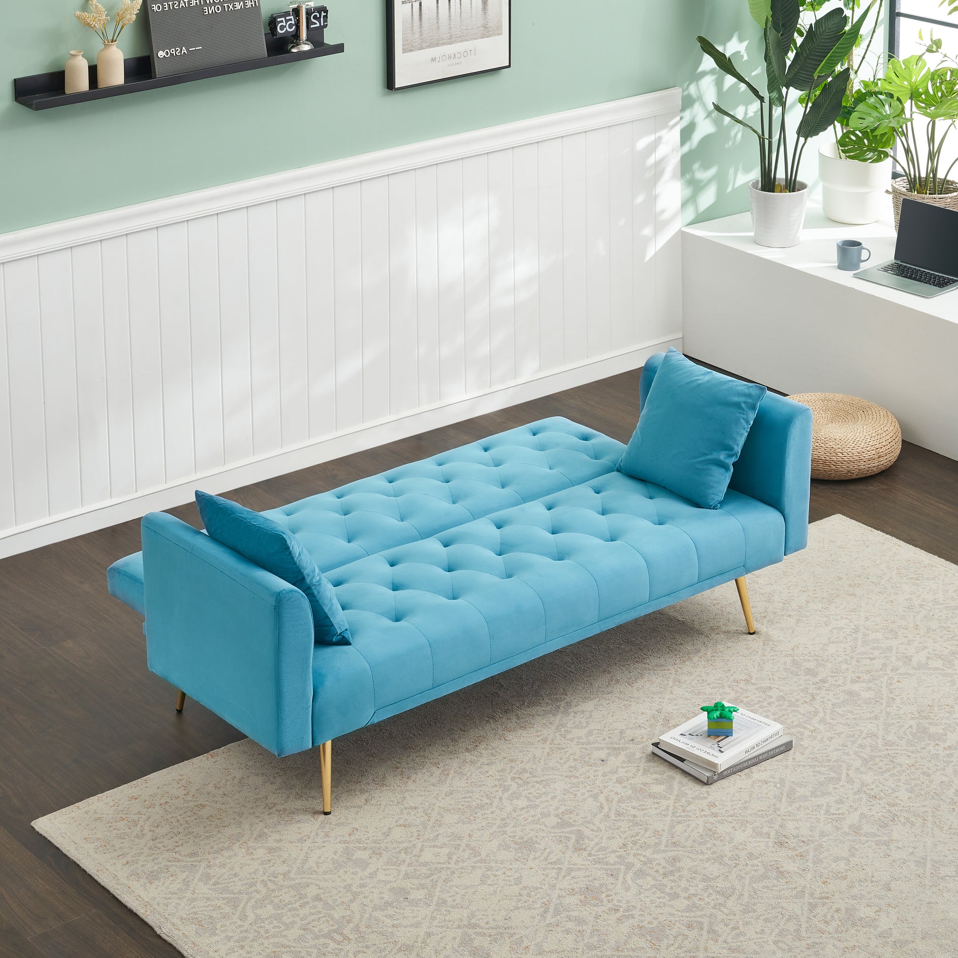 Tufted teal velvet sofa bed with gold legs and lumbar pillows