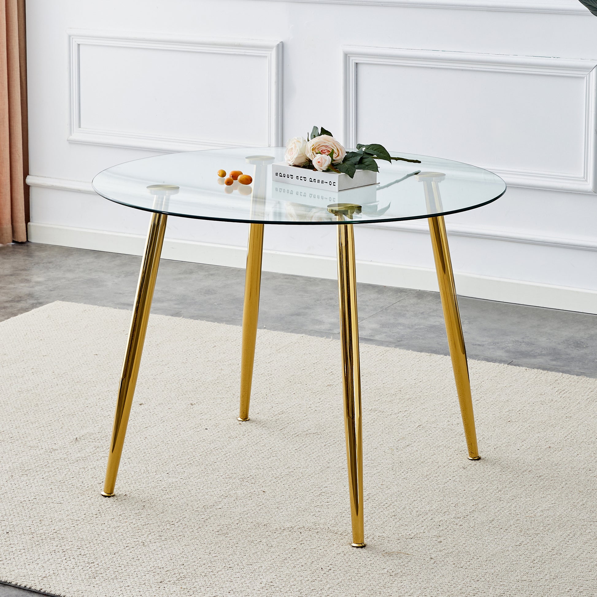 Round glass top dining table with modern gold metal legs ideal for small spaces