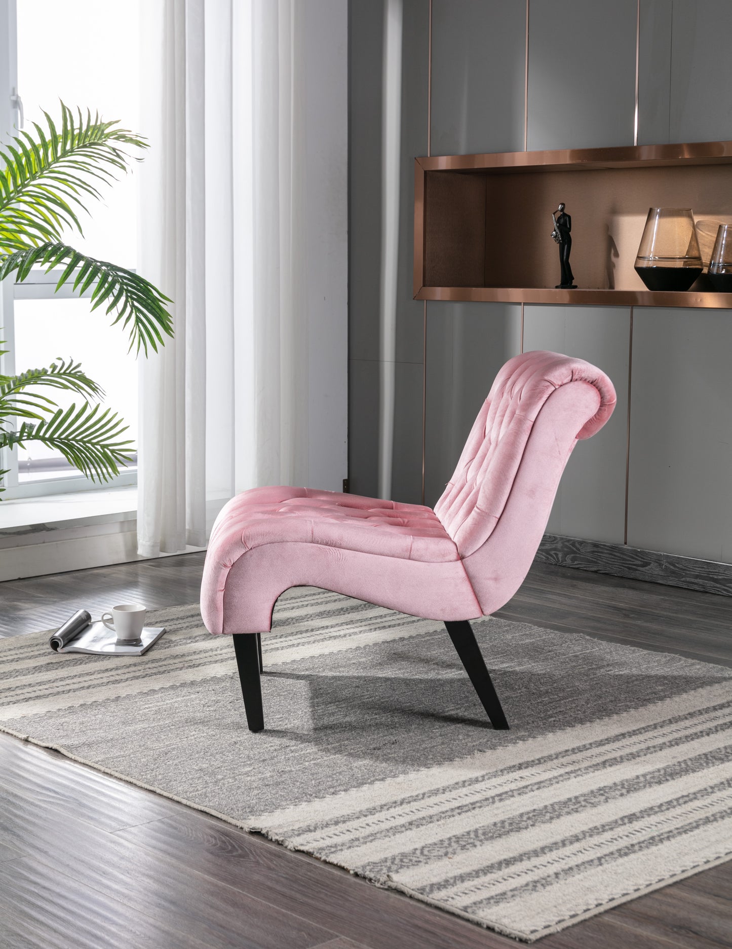 Pink velvet accent chair with tufted back and dark wood legs
