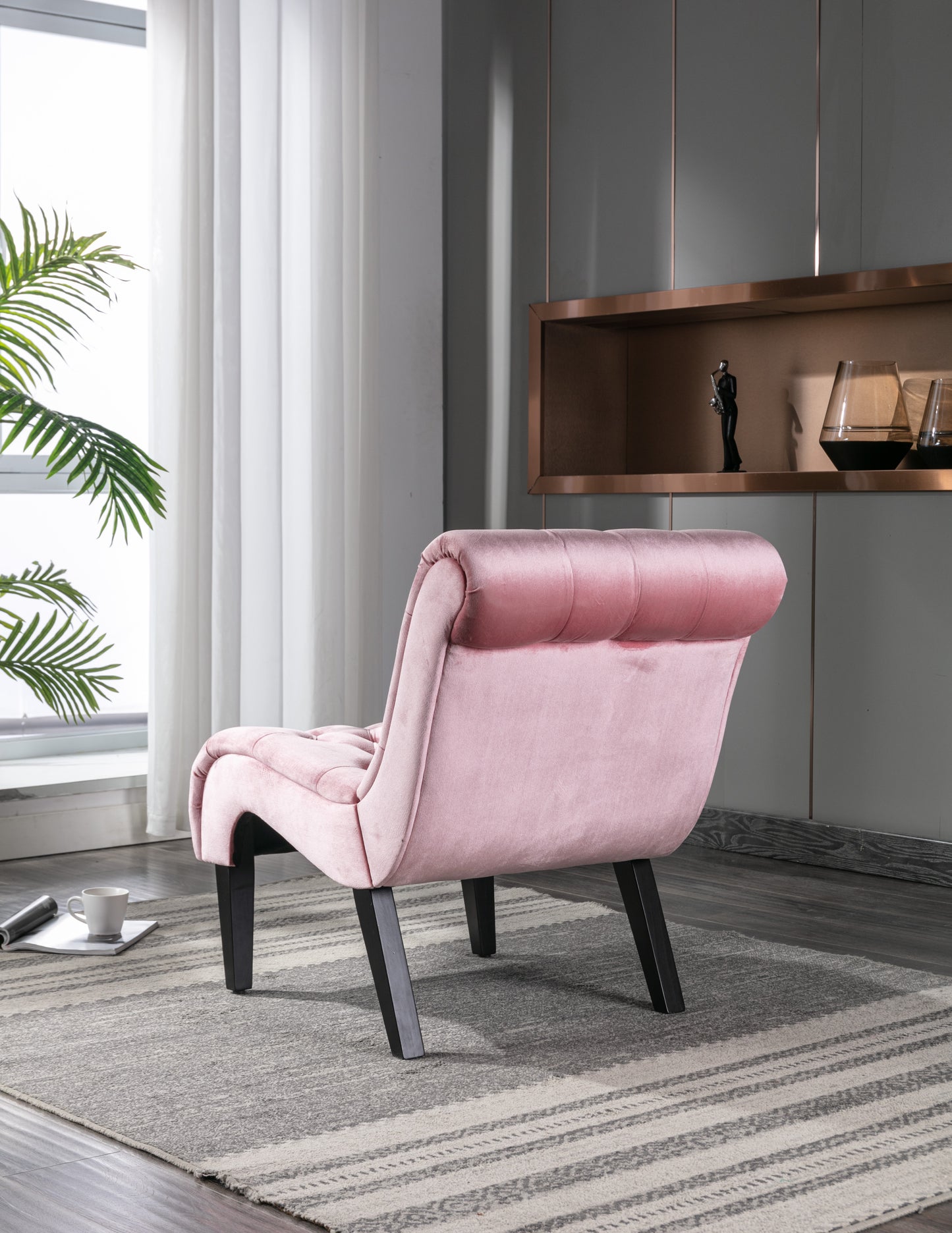 Plush pink velvet accent chair with button tufting and angled dark wood legs