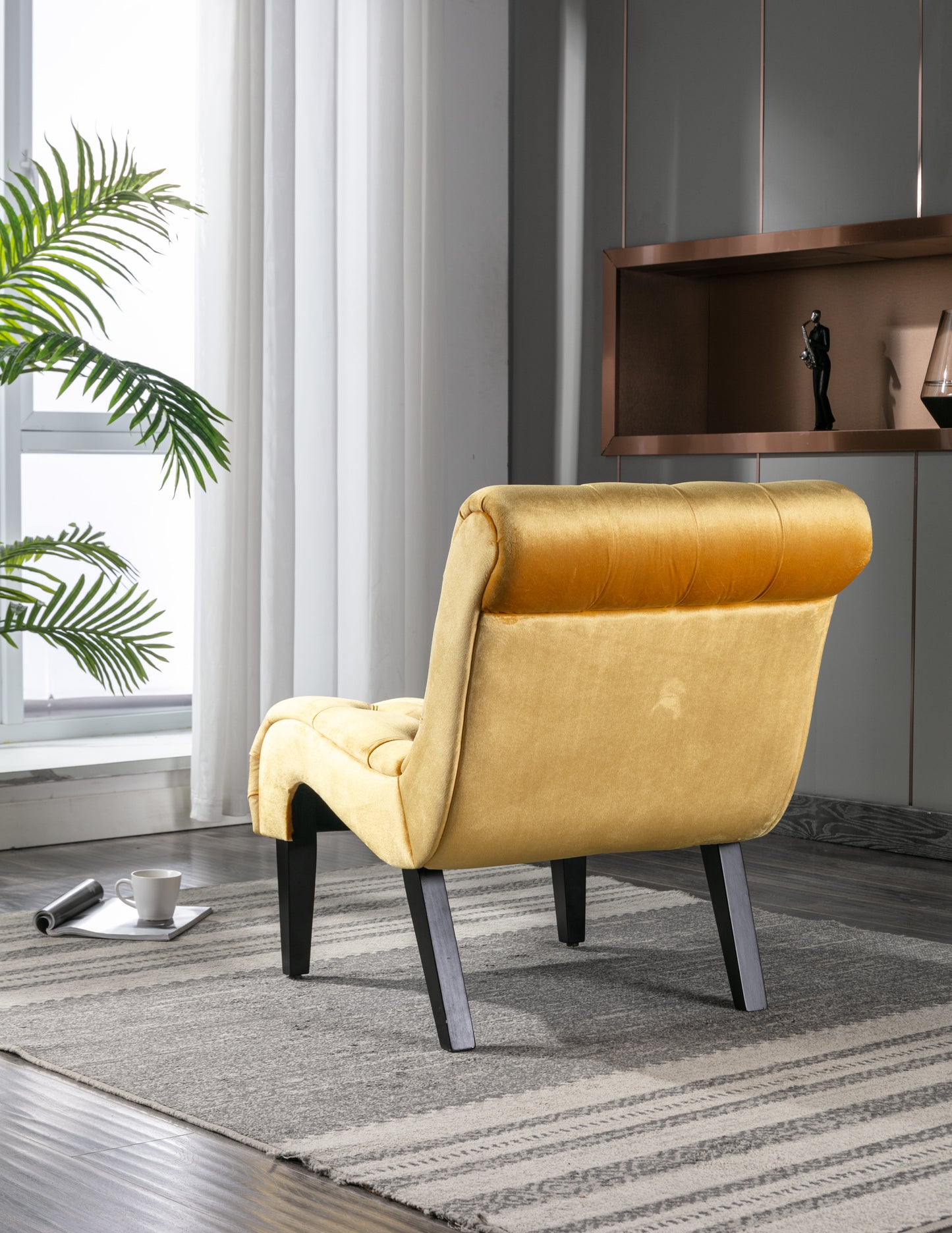 Golden velvet accent chair with button tufting and dark wood legs in a modern living room