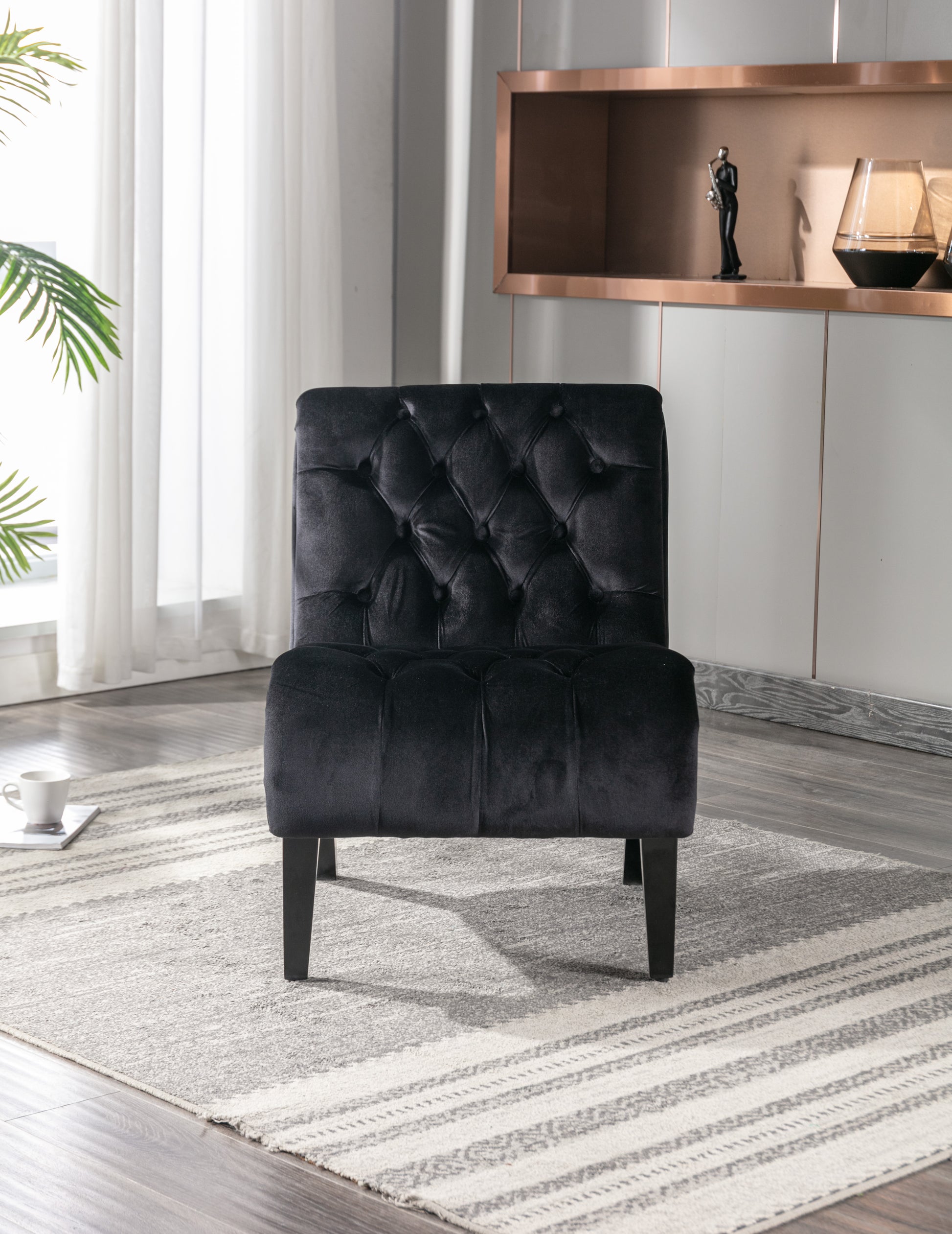 Tufted black velvet accent chair with diamond stitching and dark wood legs