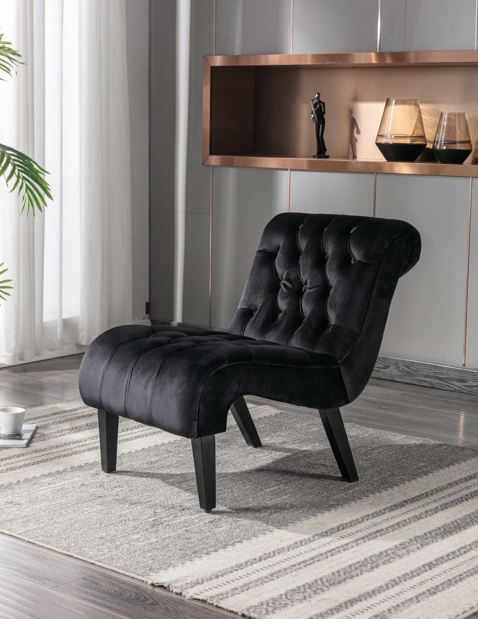 Black velvet accent chair with deep button tufting and elegant curves