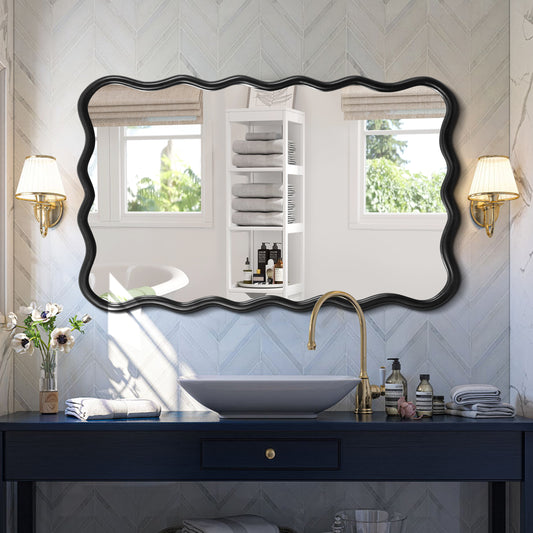Black ornate frame bathroom mirror with wavy edges reflecting a vanity and shelving unit