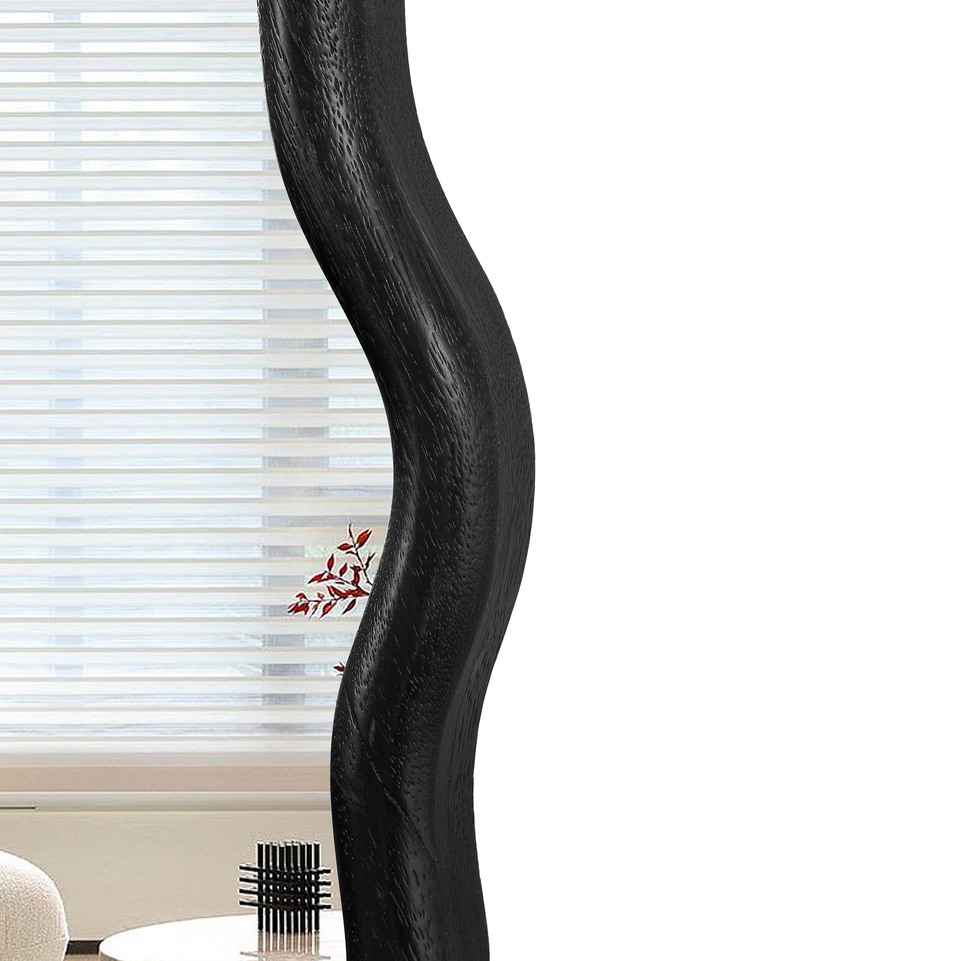 Black carved wood accent mirror with an organic flowing frame