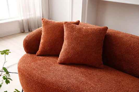 Terracotta boucl throw pillows on a modern curved sofa