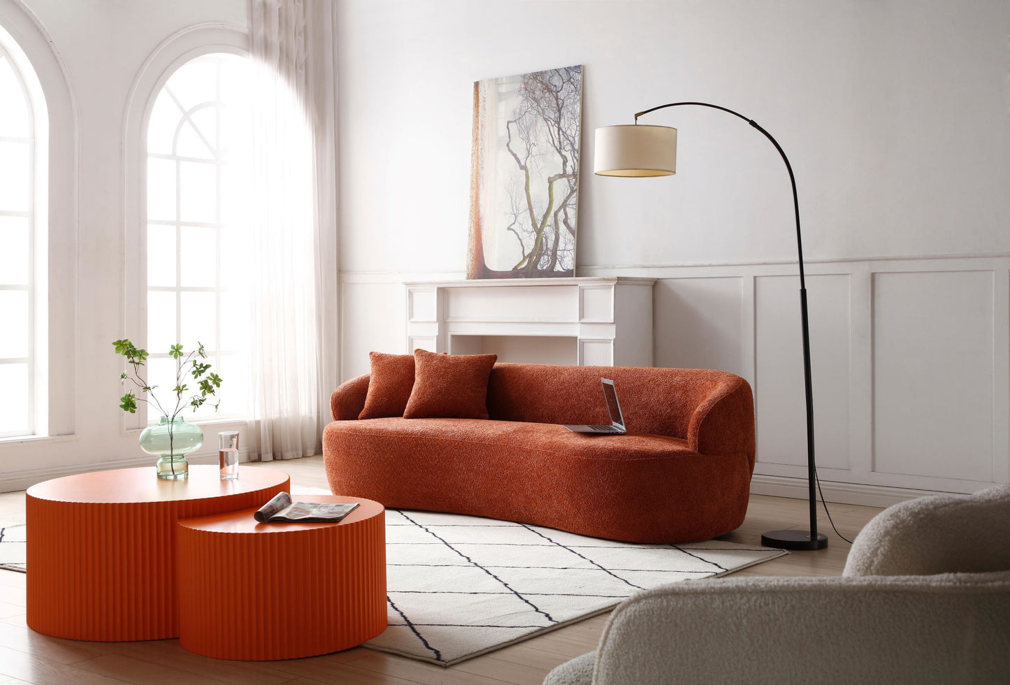 Textured orange boucle sofa with modern rounded arms and two throw pillows