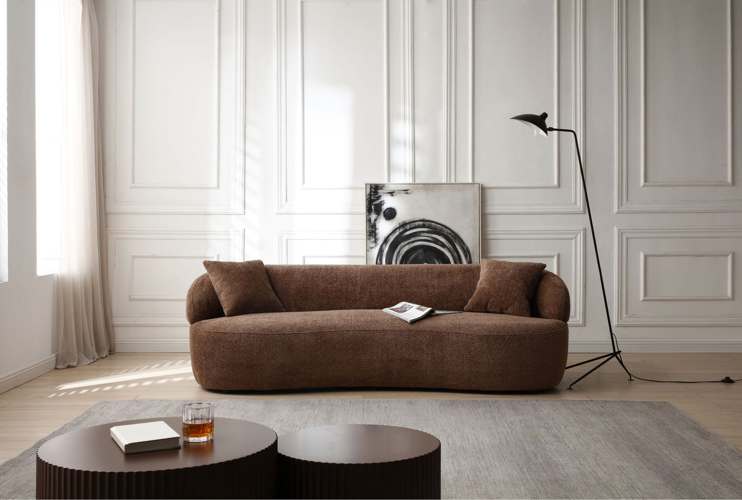 Plush brown boucle fabric sofa with curved arms and two accent pillows