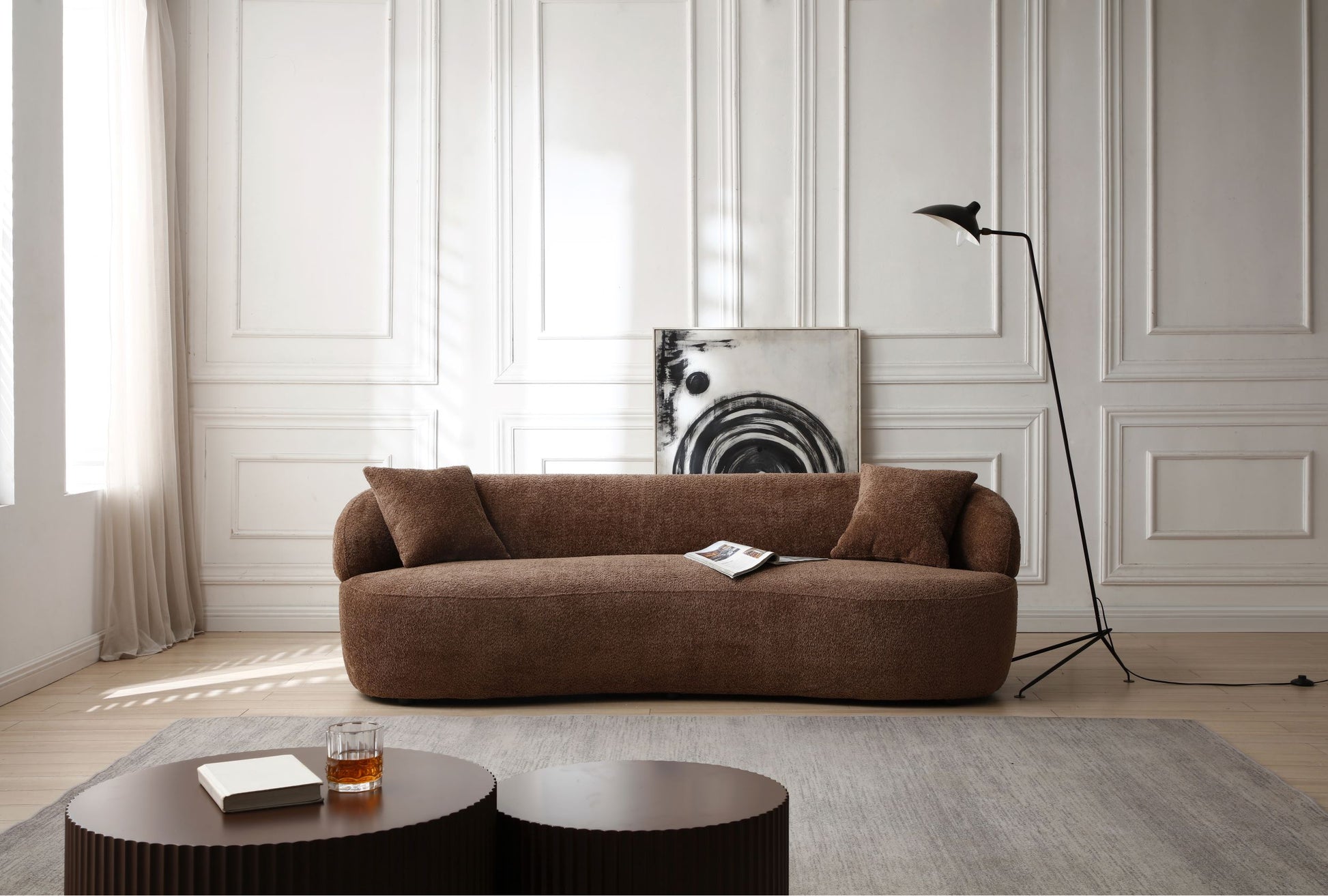 Plush brown boucle fabric sofa with curved arms and two accent pillows