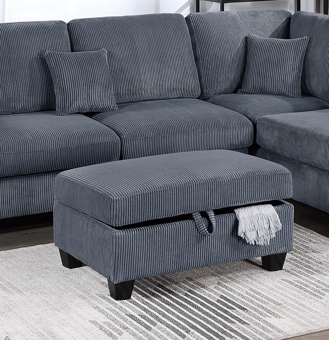 Blue corduroy sectional sofa with open storage ottoman and throw blanket