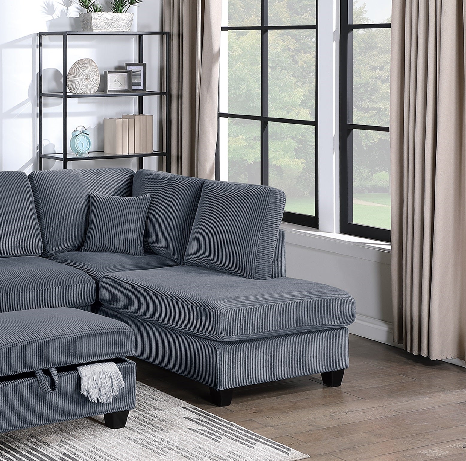 Dark grey corduroy sectional sofa with plush cushions and an ottoman