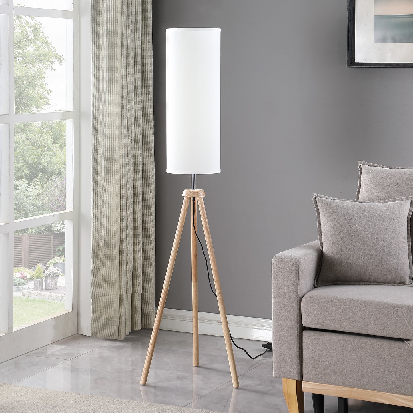 Minimalist tripod floor lamp with white fabric shade and natural wood legs perfect for modern living rooms
