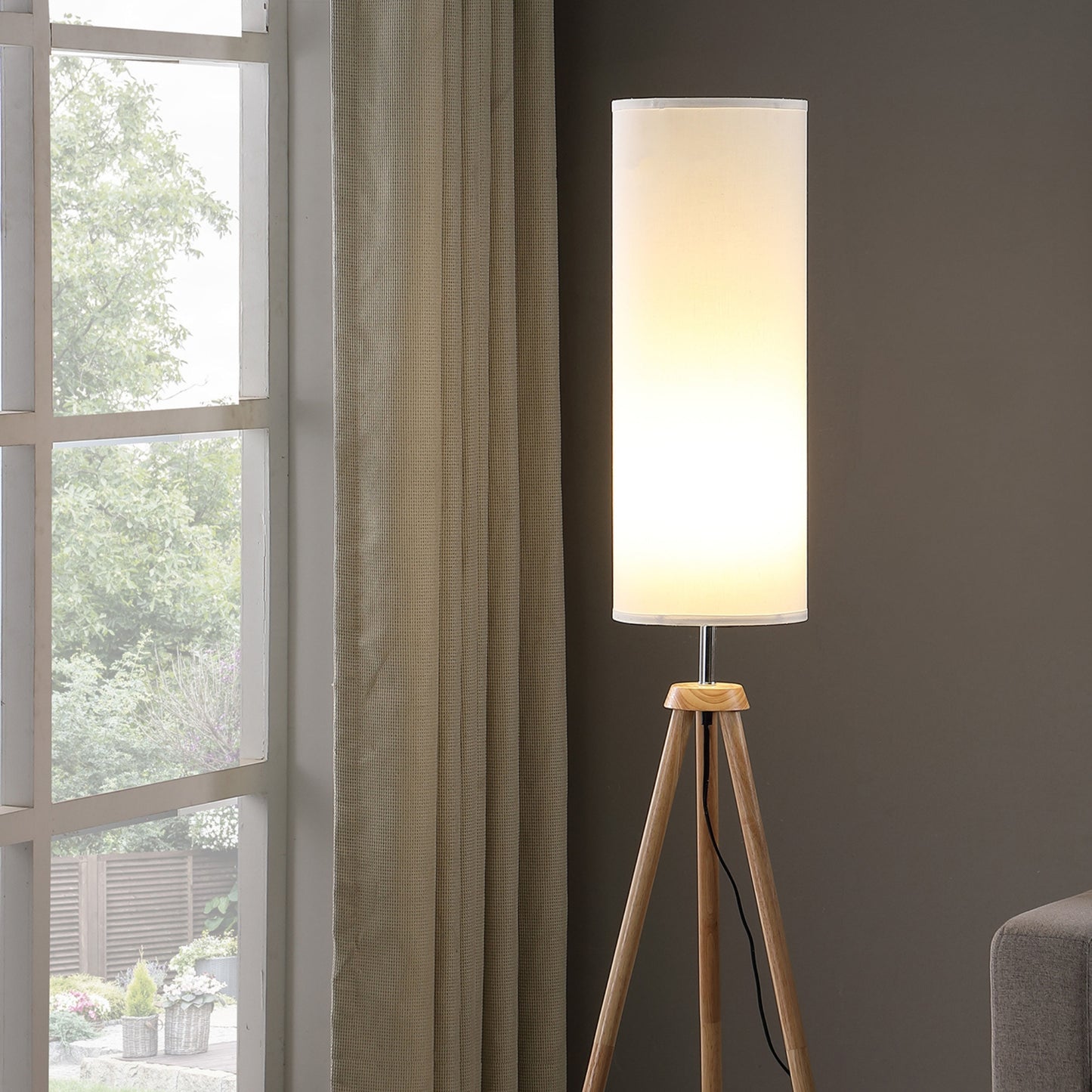 Modern floor lamp with white cylindrical shade and natural wood tripod base