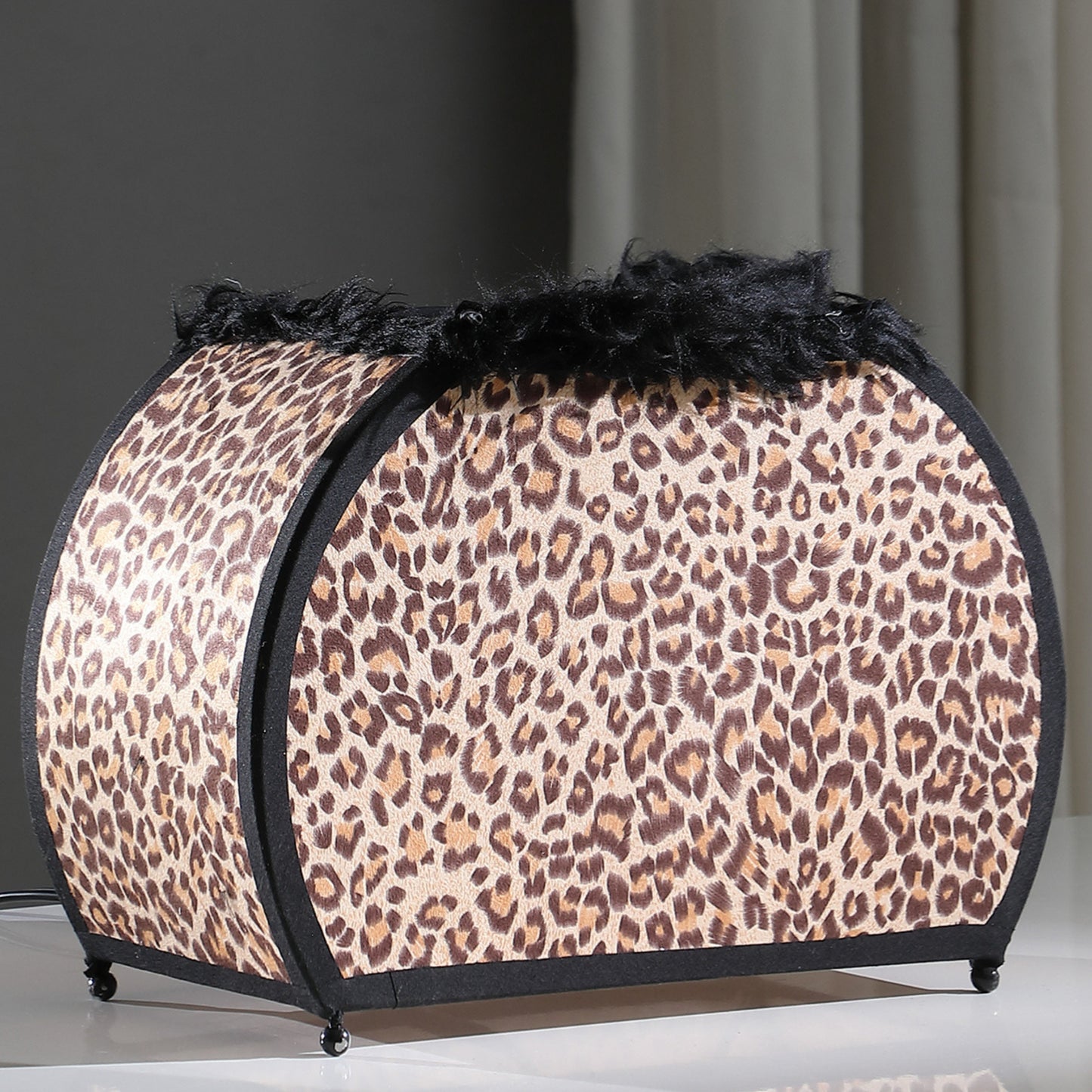 Leopard print pet bed with black trim and fluffy top offering cozy comfort for small animals