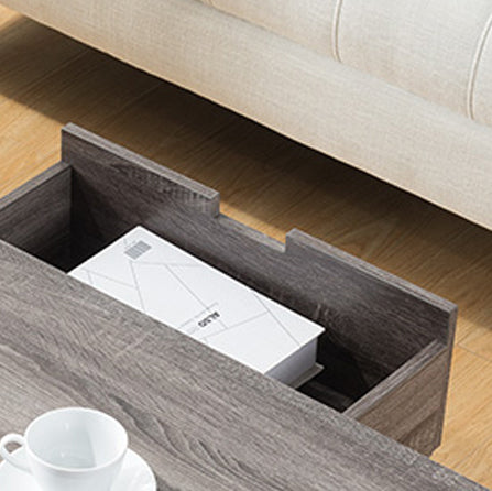 Rustic gray wood coffee table with open storage drawer holding a white book