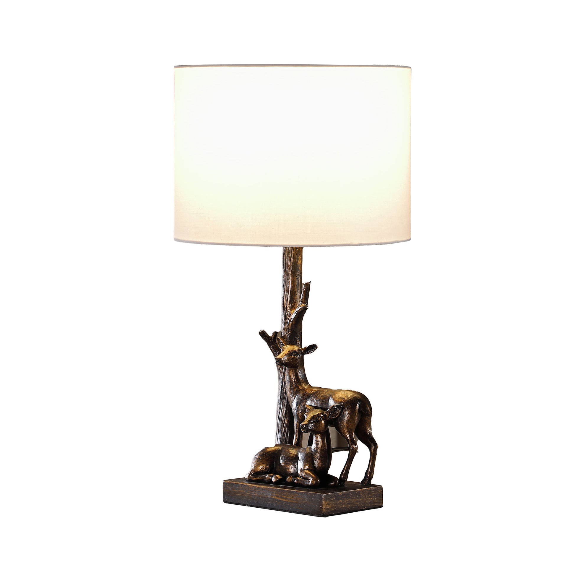 Bronze deer table lamp with a white drum shade featuring a doe and fawn beside a tree trunk